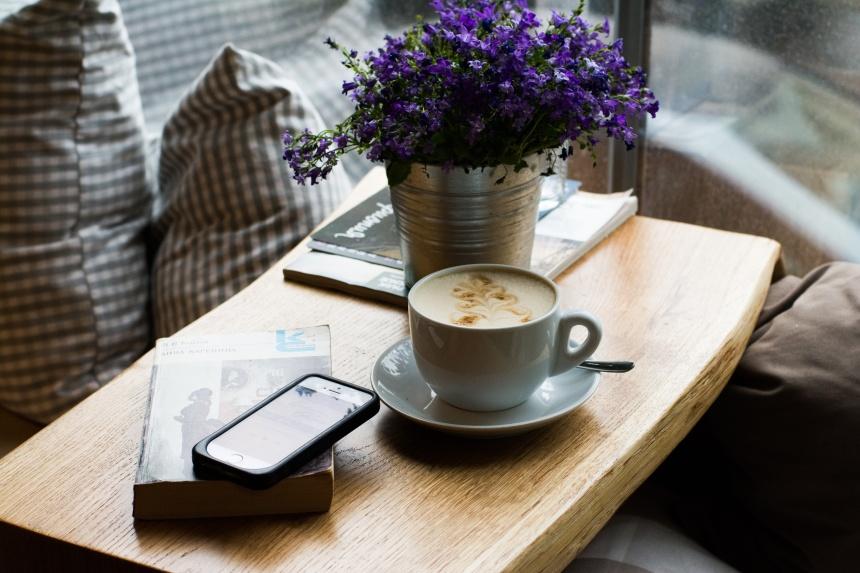 Фиолетовые цветы на столе, чашка кофе. Фото: Photorobus.ru